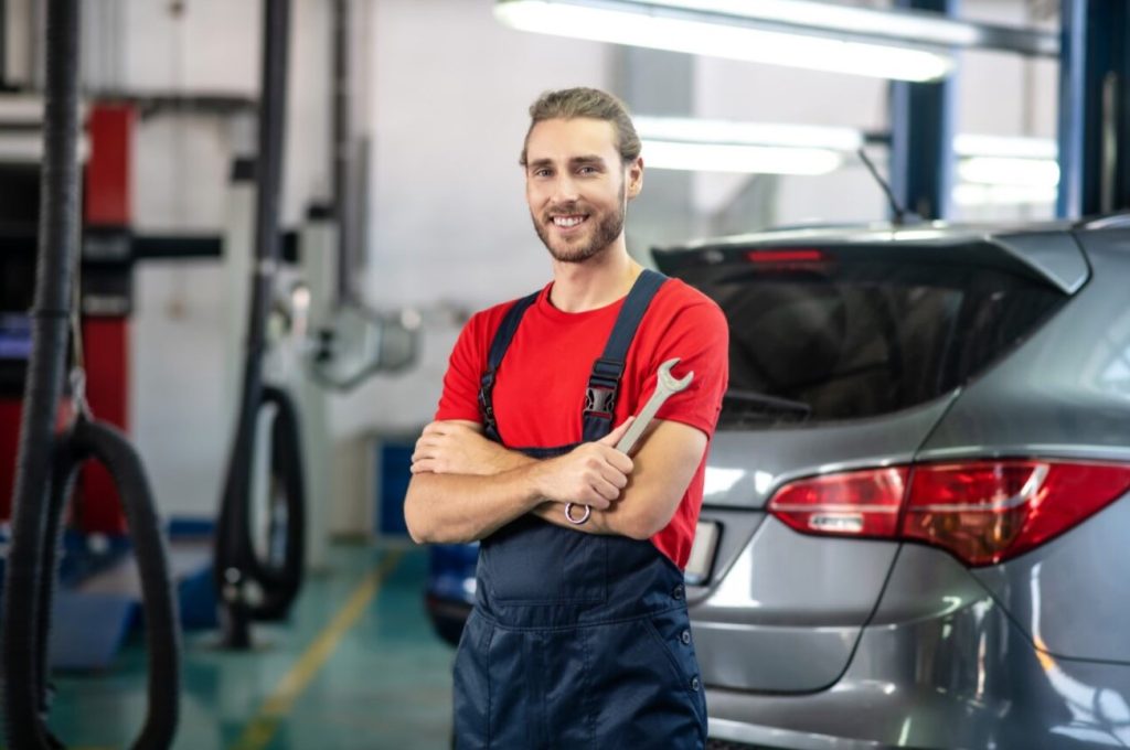 technician standing next to a Chevy smiling