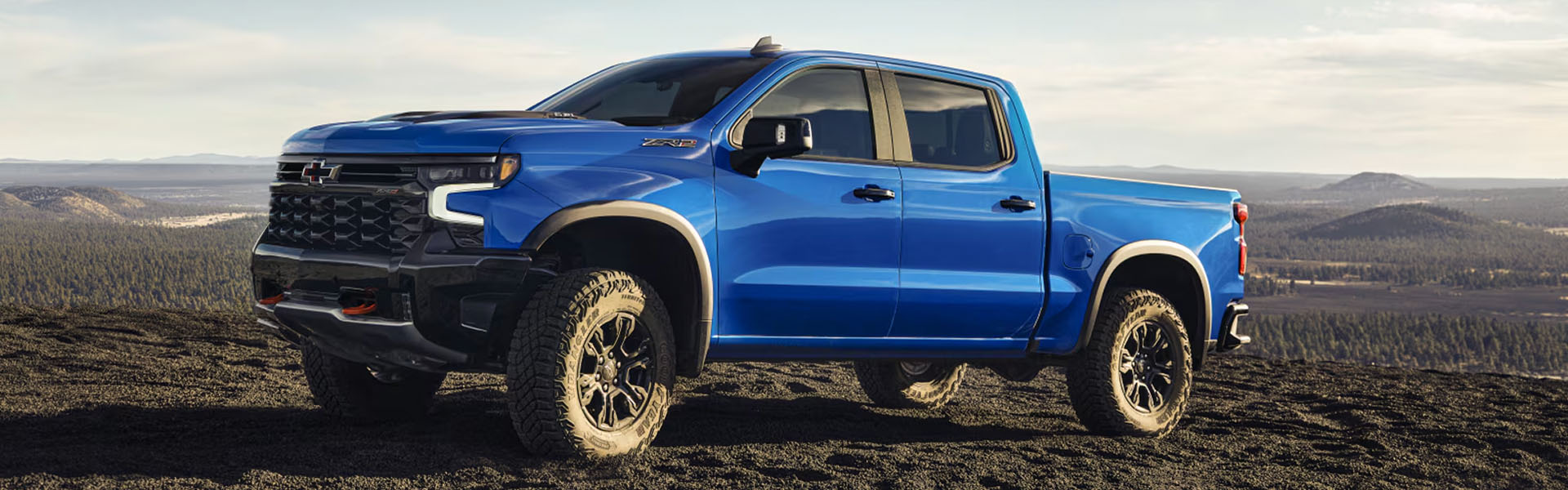 Blue Chevrolet Silverado truck on rugged terrain.